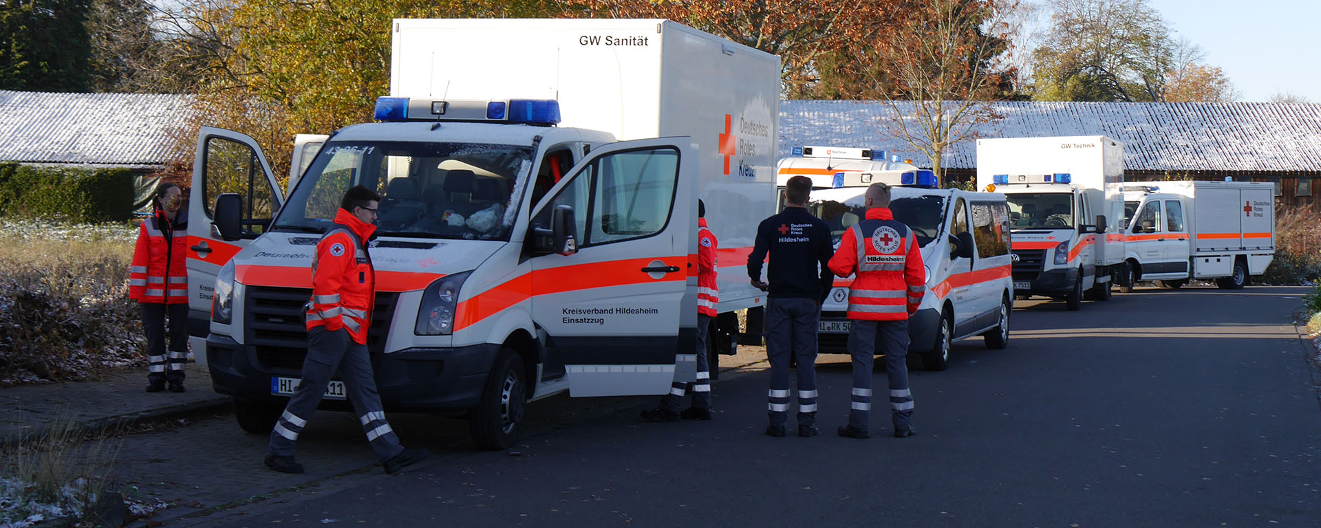 Übung des Sanitäts- und Betreuungszuges. Mehrere Fahrzeuge stehen am Straßenrand, dazwischen bewegen sich Einsatzkräfte.