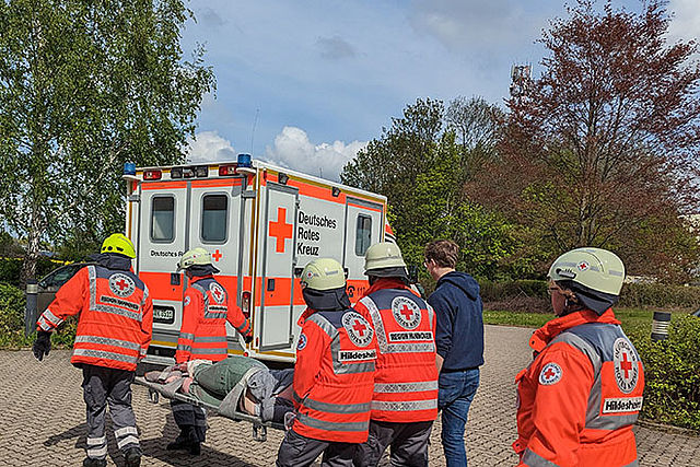 DRK-Einsatzkräfte bringen Verletzten zum RTW.