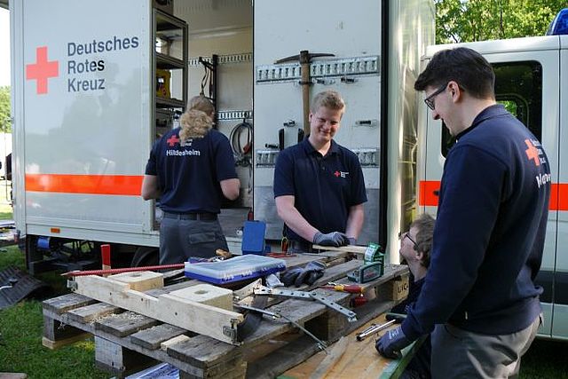 Einsatzkräfte bei der Holzbearbeitung vor dem GW Technik.