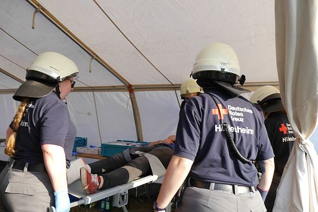 Sanitäter versorgen einen Verletzten in einem Zelt.