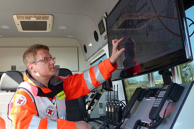 Einsatz-Situation im ELW. DRK-Abschnittsleiter zeigt auf Monitor.